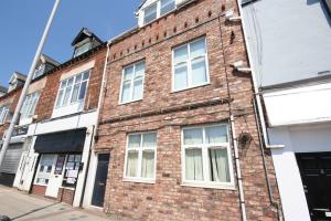 a brick building with white windows on a street at MARLEY MANSIONs APARTMENTS - KING ST REF : 10/3 in Wallasey