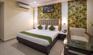 Pokój hotelowy z łóżkiem i krzesłem w obiekcie Hotel City Center Jodhpur w mieście Dźodhpur