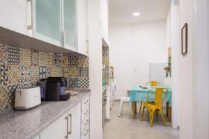 リスボンにあるFeel@home Lisboaのキッチン(テーブル、黄色い椅子付)