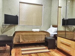 KhorogZarya Hotel的一间带床和平板电视的卧室