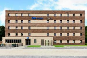 a large brick building with a sign on it at ibis budget Stein Maastricht in Stein