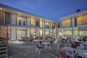 a hotel with tables and chairs in front of a building at Welcome In in Aveiro