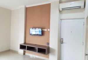 a room with a flat screen tv on a wall at Ethan Hotel Kelapa Gading in Jakarta +16 photos