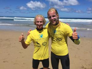 two men giving thumbs up on the beach at Wellenkind Surfschool in La Pared