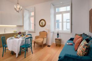 a living room with a table and a blue couch at Once Upon Lisboa Family Units in Lisbon