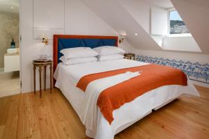 リスボンにあるAurea Once Upon Houseのベッドルーム1室(大型ベッド1台、オレンジの毛布付)