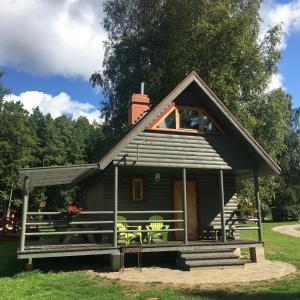 a small cabin with a porch and chairs in the grass at Bukdangas in Usma