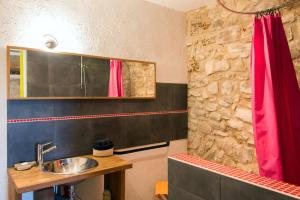 ein Badezimmer mit einem Waschbecken und einem roten Duschvorhang in der Unterkunft La Belugue in Beaumont-de-Pertuis + 48 Fotos