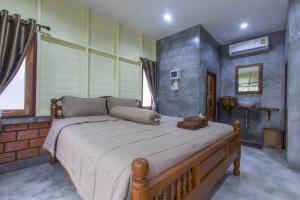 1 dormitorio con 1 cama grande en una habitación en P's cottage บ้านพักในสวนสวย en Trang