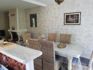 Villa La Milouyette في Peyriac-Minervois: غرفة طعام مع طاولة بيضاء وكراسي الخوص