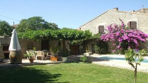 - Vistas al exterior de una casa con piscina y sombrilla en Villa La Milouyette, en Peyriac-Minervois