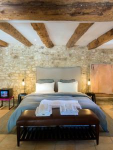 a bedroom with a bed and a stone wall at La Belugue in Beaumont-de-Pertuis