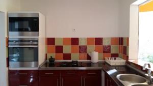 a kitchen with a sink and a stove top oven at Éden Évasion in Sainte-Rose