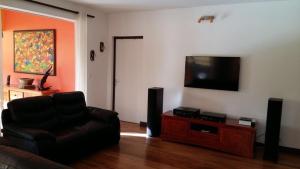 a living room with a couch and a flat screen tv at Éden Évasion in Sainte-Rose