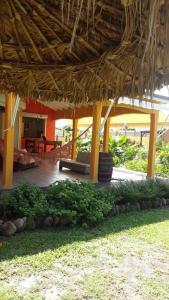 a porch of a resort with a bench and a straw roof at Éden Évasion in Sainte-Rose