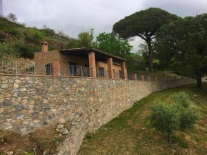 un mur en pierre avec une maison en haut dans l'établissement Belvilla by OYO Tuono, à Cetraro