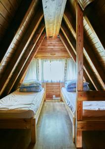 ジキにあるDomki Czarny Grońのベッドルーム(ベッド2台付)が備わる屋根裏部屋です。