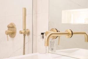 a bathroom with a sink and gold faucet at House of Amstel in Amsterdam