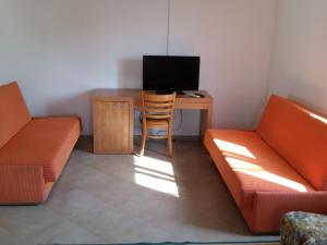 a room with a desk with a computer and a couch at Apartments Lorena in Zadar