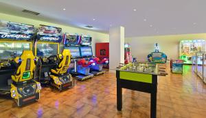 a room with several arcade games and a table at Sol Puerto Marina in Torremolinos