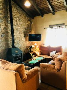 a living room with two couches and a fireplace at Rural Pedroches Casa Los Mineros in Villanueva del Duque