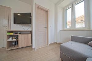 a living room with a couch and a flat screen tv at Villa Radić in Ston