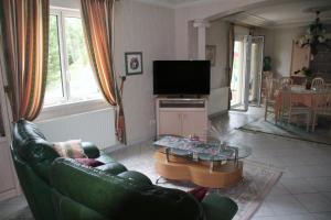 a living room with a couch and a table at Domaine de la Pendule in Issel