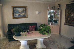 a living room with a green couch and a table at Domaine de la Pendule in Issel