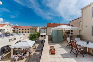 a patio with tables and umbrellas on a building at Apartment Keti in Novalja