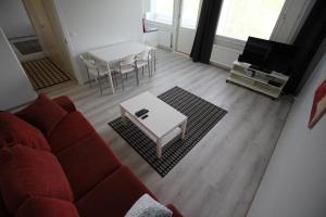 a living room with a red couch and a table at Apartment Kirkkokatu in Raahe