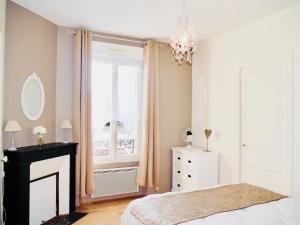 エペルネーにあるLa Bulle de Champagneのベッドルーム1室(ベッド1台、窓、シャンデリア付)