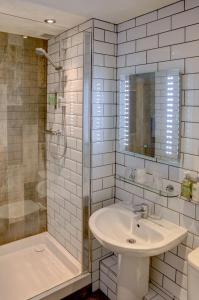 a white bathroom with a sink and a shower at Beck Hall in Malham