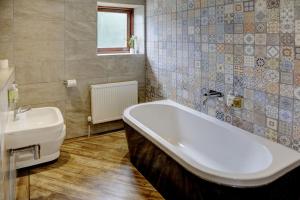 a bathroom with a bath tub and a sink at Beck Hall in Malham