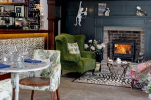 a living room with a fireplace and a green chair at Beck Hall in Malham