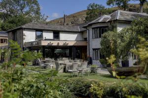 a building with tables and chairs in front of it at Beck Hall in Malham