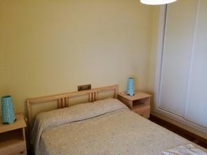 a small bedroom with a bed and two night stands at Apartamento cercano a la playa con gran terraza in Torre de Benagalbón