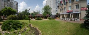 a park in the middle of a city with buildings at Galant Hotel in Boryspilʼ