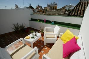 een patio met stoelen en een tafel op een balkon bij Archeros Skyview by Valcambre in Sevilla