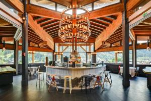 a bar in a restaurant with a chandelier at Alpina Eclectic Hotel in Chamonix