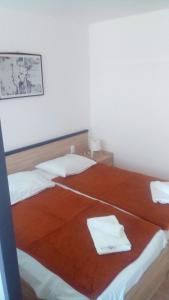 1 dormitorio con 2 camas y toallas. en Apartments Hostin Garoful Duga Uvala, en Krnica