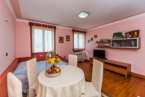 a living room with a table and chairs and a television at Apartment Keti in Novalja