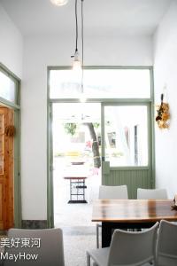 a dining room with a table and a window at Mayhow Donghe in Donghe