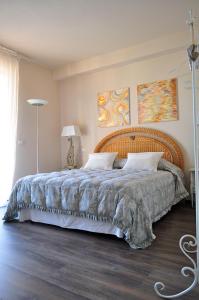 a bedroom with a large bed with a wooden headboard at B&B Acquamarina in Marina di Massa