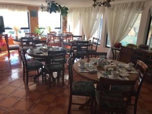 a dining room with many tables and chairs and windows at Hostal Español Coyhaique in Coihaique
