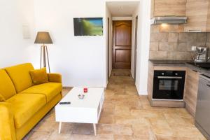 a living room with a yellow couch and a table at A Suara Di Mare in Ghisonaccia