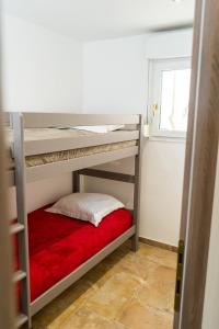 A Suara Di Mare في جيزنوكسيا: غرفة نوم مع سرير بطابقين مع بطانية حمراء