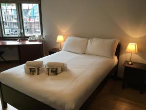 a bed with two towels and two lamps on it at West Court- Jesus College in Cambridge