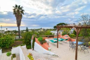 a patio with tables and chairs and a view of the ocean at Residence Limoneto Ischia in Forio d'Ischia