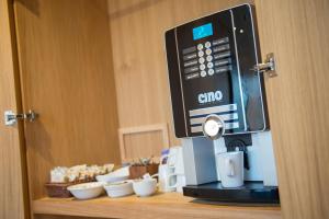 a coffee machine sitting on top of a shelf with bowls at West Court- Jesus College in Cambridge