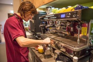 a man is preparing food in a kitchen at West Court- Jesus College in Cambridge